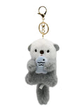 Fluffy plush otter keychain holding little fish, kawaii bag accessory