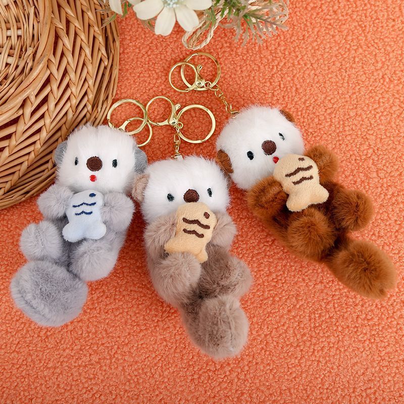 Cute otter plush charm hanging on backpack, animal lover gift